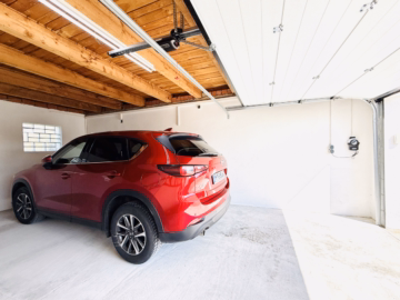 Auto in der überlangen Garage - Extravaganter Bungalow mit Doppelgarage, renoviert und saniert, großer Garten in Königsbrunn kaufen